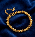 Gold bracelet on a blue fabric background