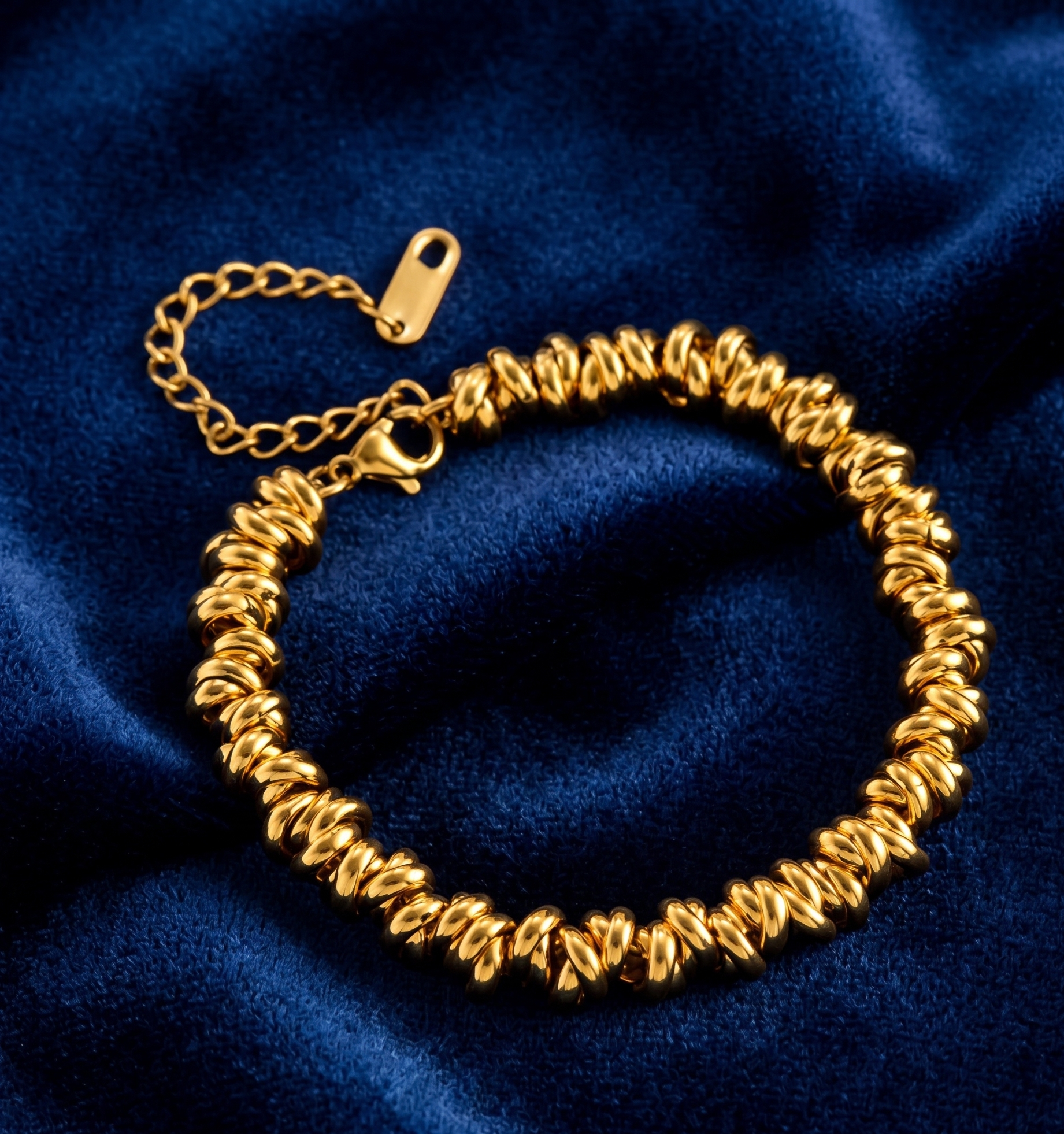 Gold bracelet on a blue fabric background