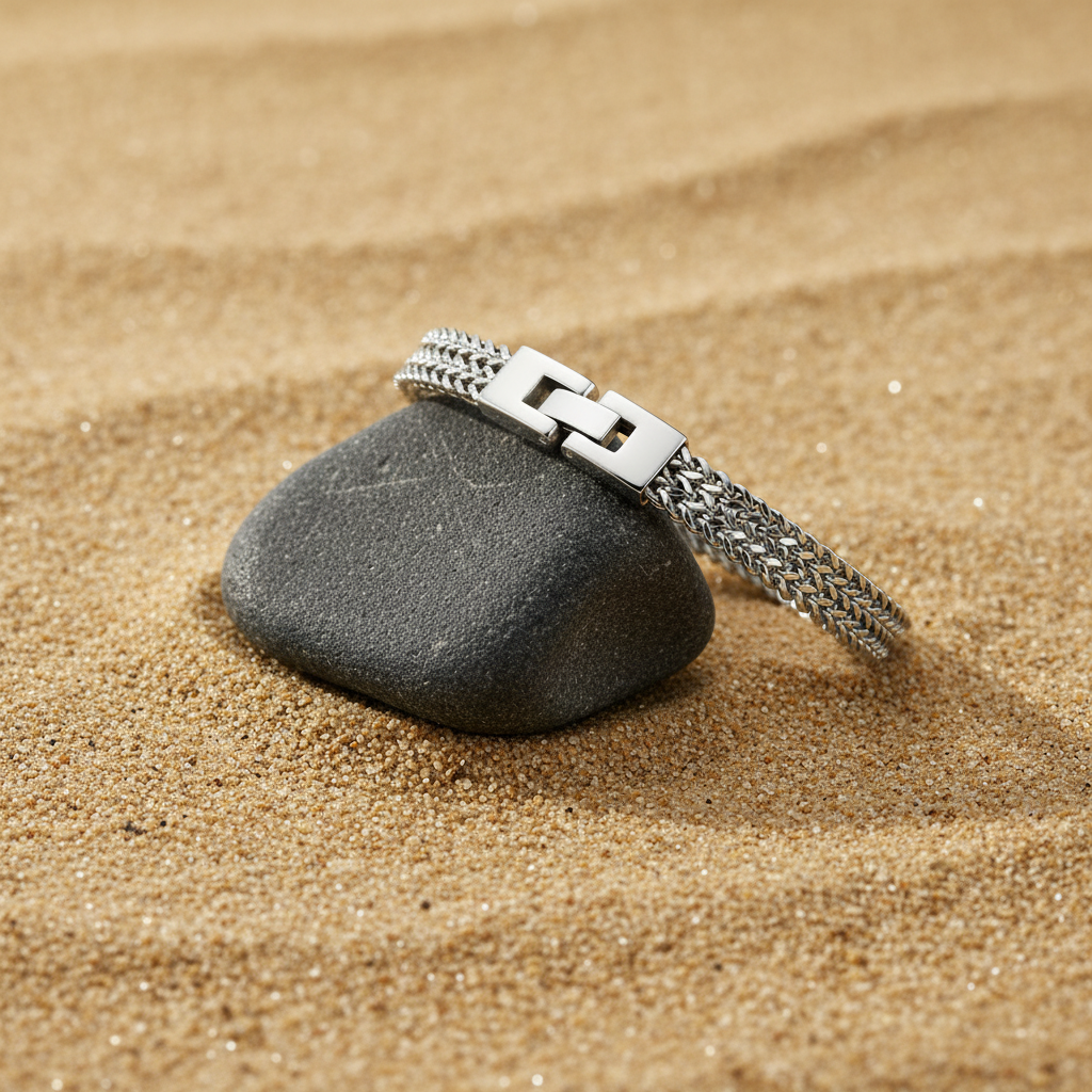 Silver bracelet on a gray stone in sand