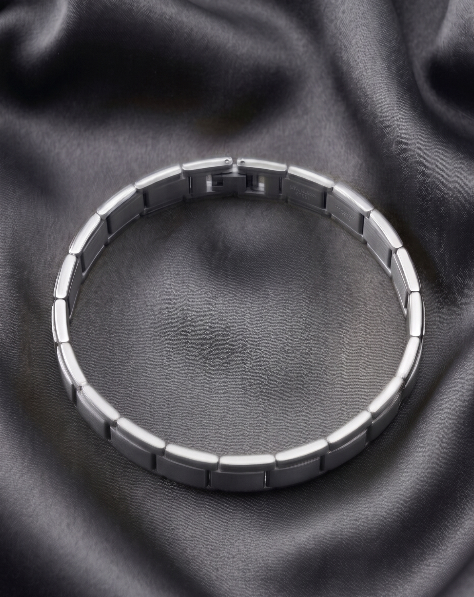 Silver bracelet on a dark fabric background