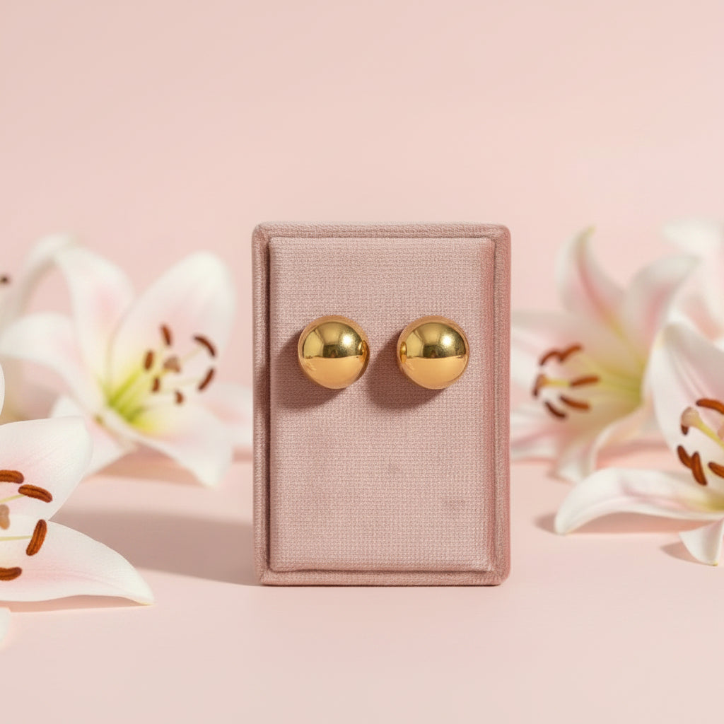 Pair of gold earrings on a light fabric background