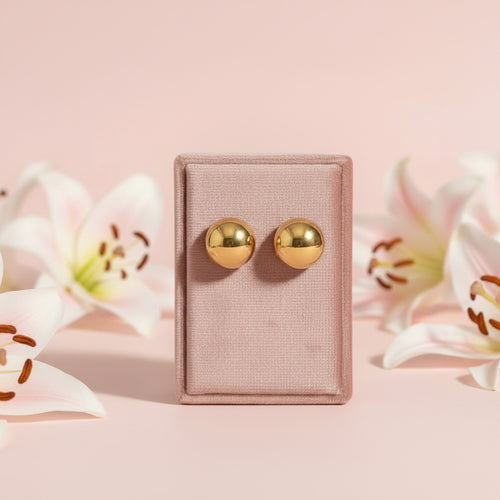 Pair of gold earrings on a light fabric background