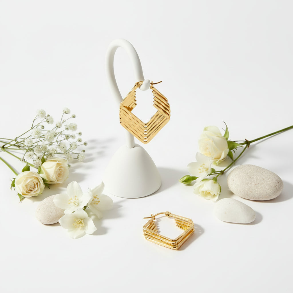 Gold hoop earrings with geometric design on a white background