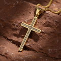 Gold cross pendant with clear stones on a dark surface