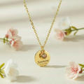 Gold engravable gemstone coin necklace on black background